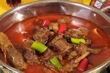 鸭肉火锅用铁锅盛着,里面放适量汤汁,架在火锅上,将汤烧热,鸭肉散