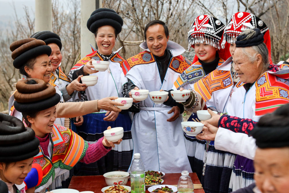 在位于乌蒙山区腹地的贵州省毕节市纳雍县，村民马雍（右五）与妻子黄国琴（左五）在年夜饭上与大家干杯（2021年2月11日摄）。